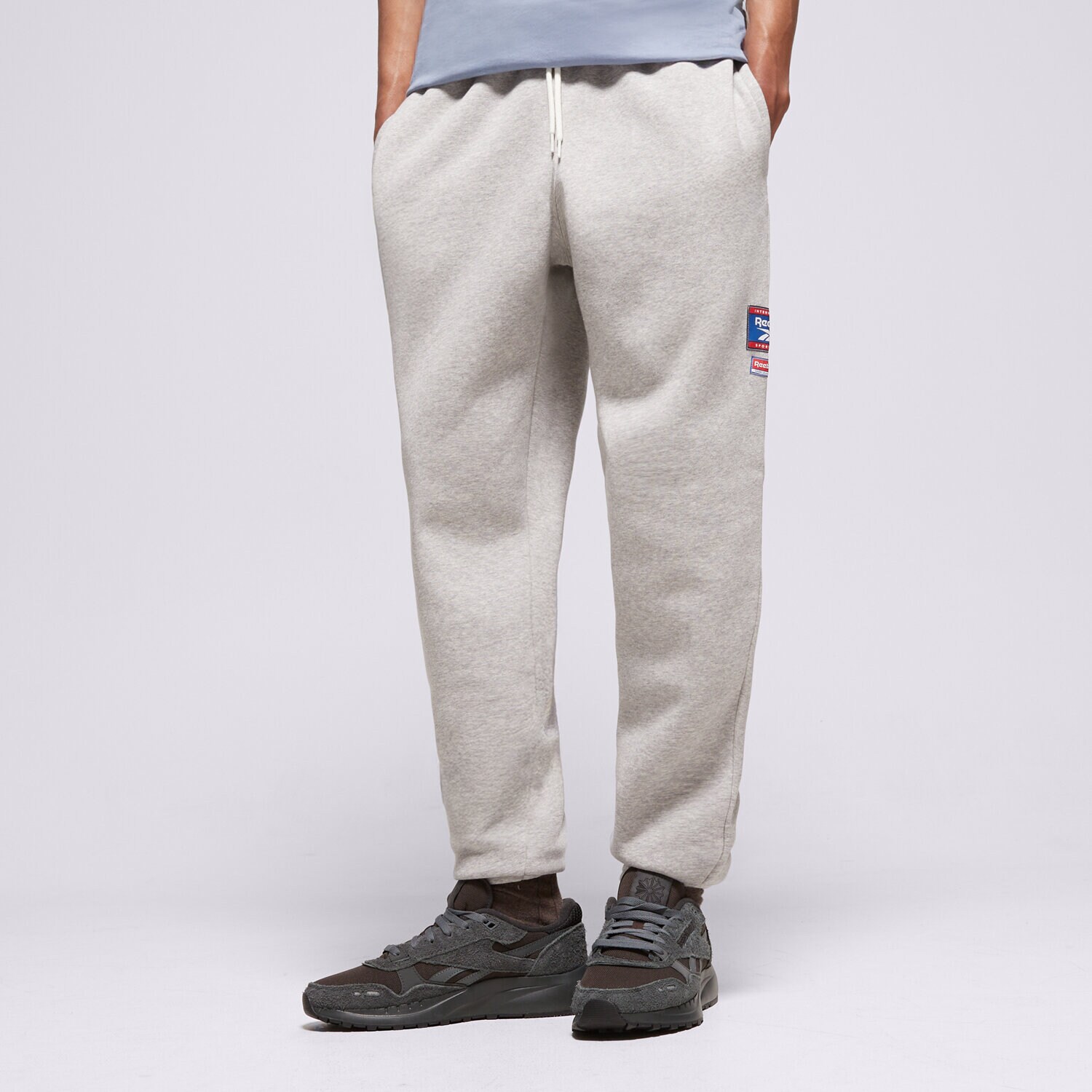 pánské kalhoty REEBOK KALHOTY  RI BADGE 100205445 ŠEDÁ