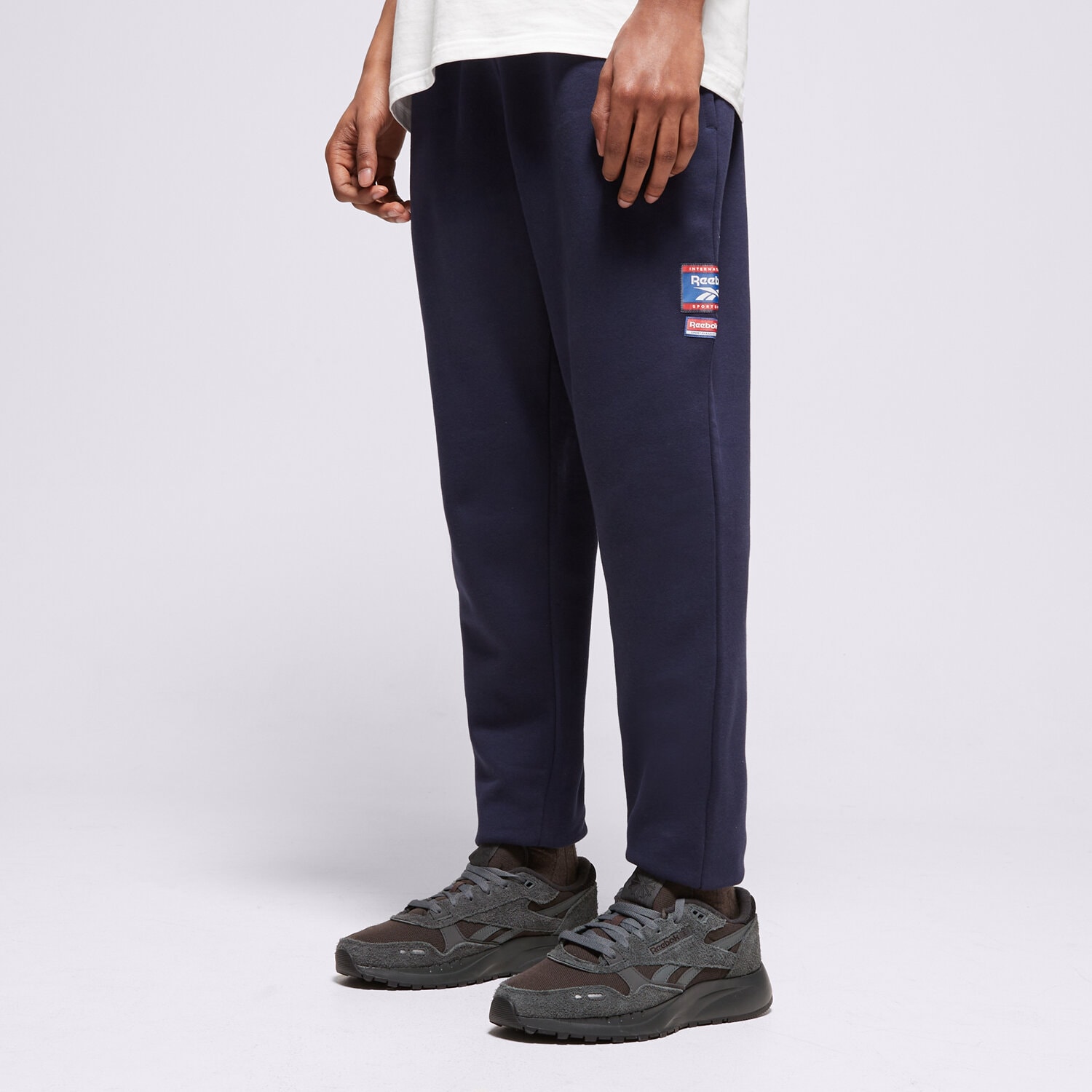 pánské kalhoty REEBOK KALHOTY  RI BADGE 100205446 TMAVOMODRÁ
