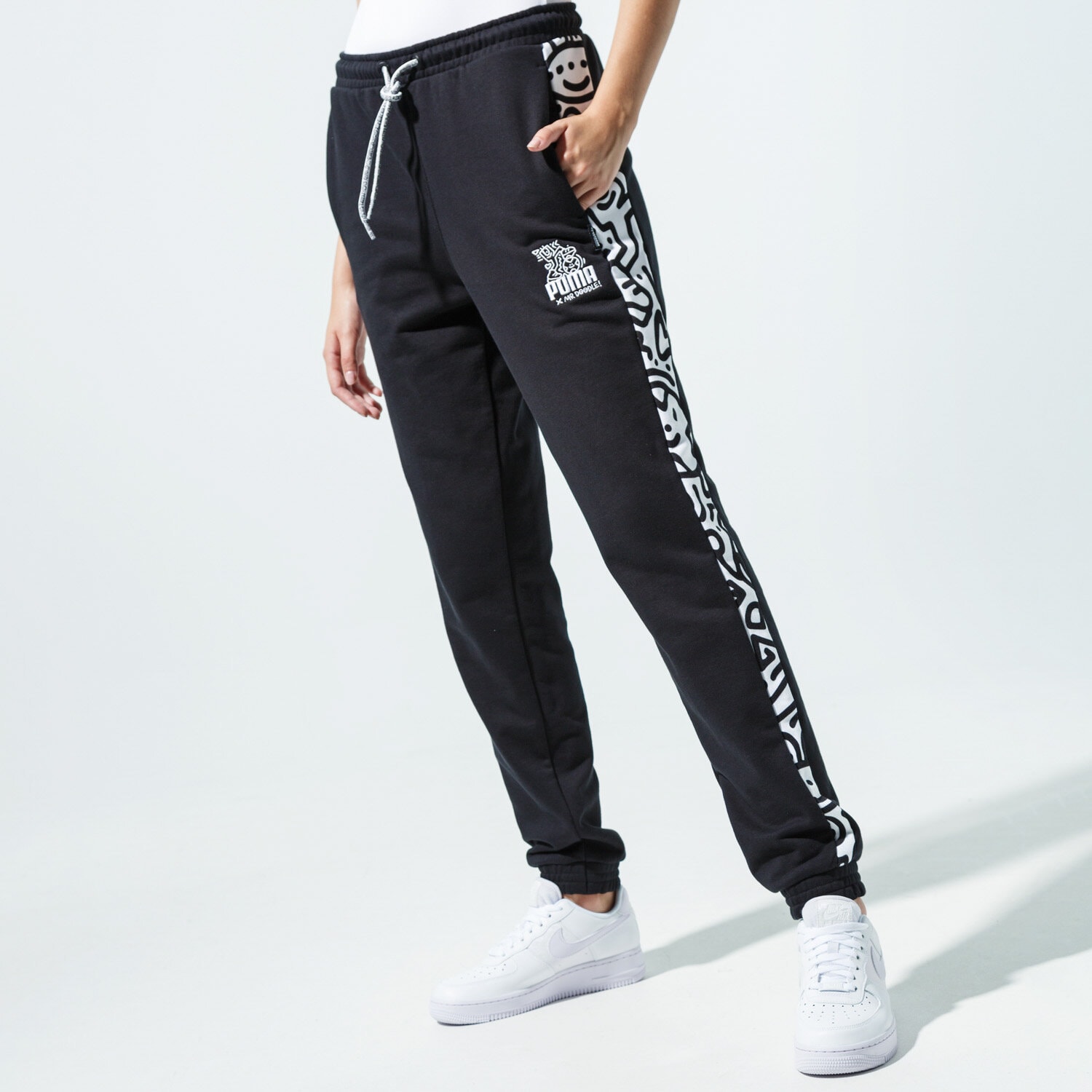 dámské kalhoty PUMA KALHOTY  PUMA X MR DOODLE PANTS 59865051 ČERNÁ